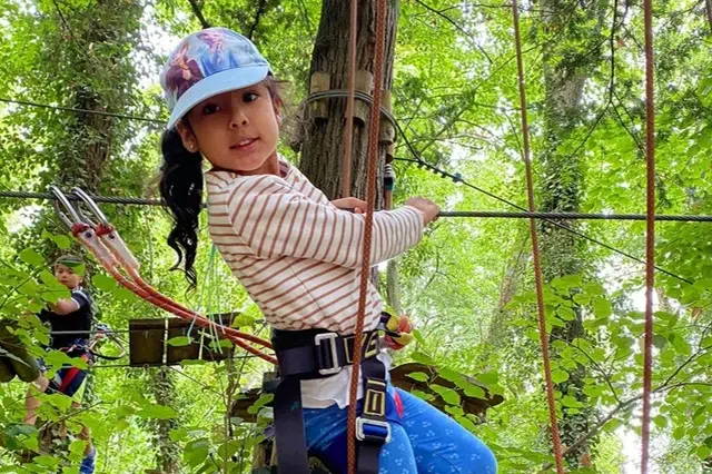 Petite fille faisant de l'accrobranche l'été